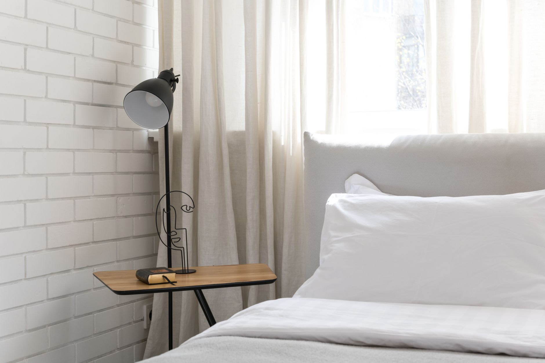 A calm, minimal bedroom in warm natural light